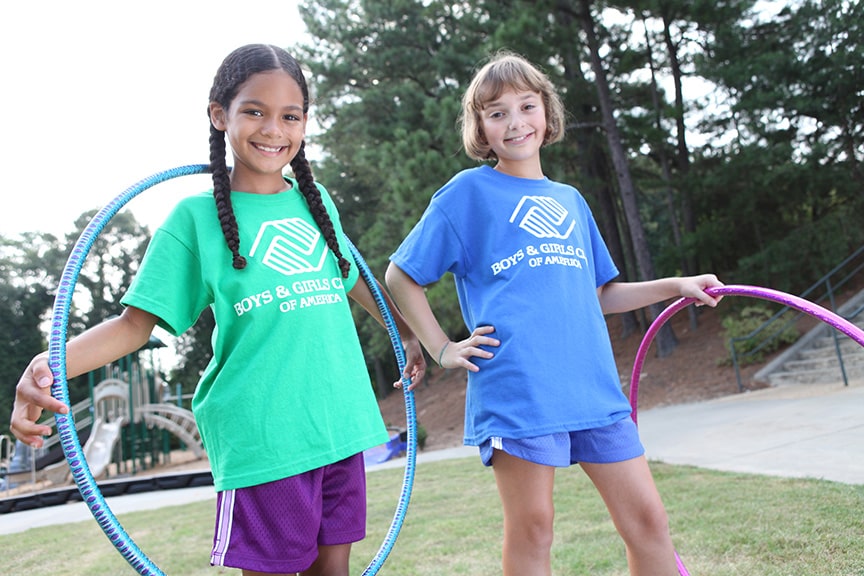 Two young girls with hoola hoops at a park