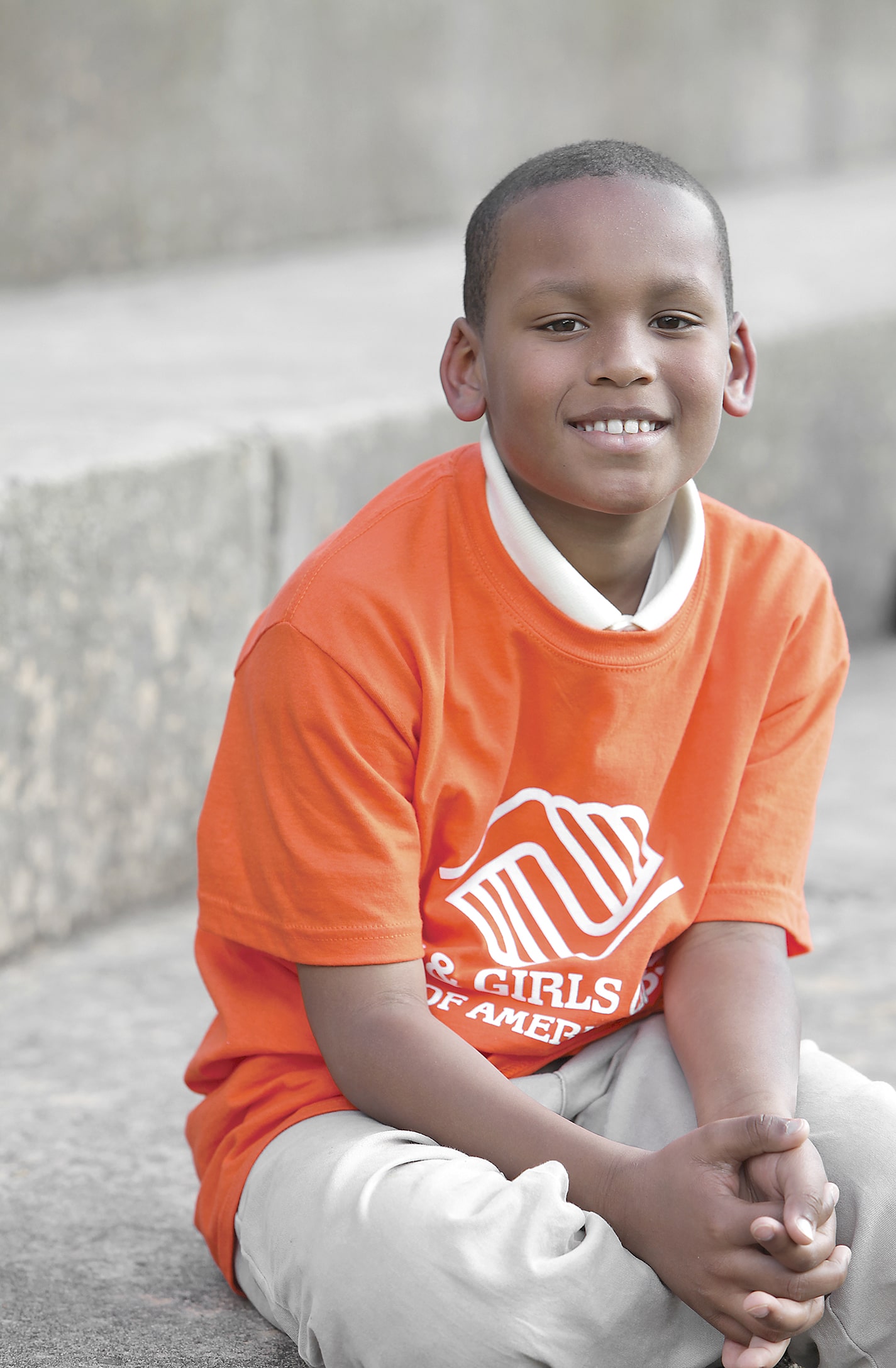 boy sitting on steps wearing club apparel